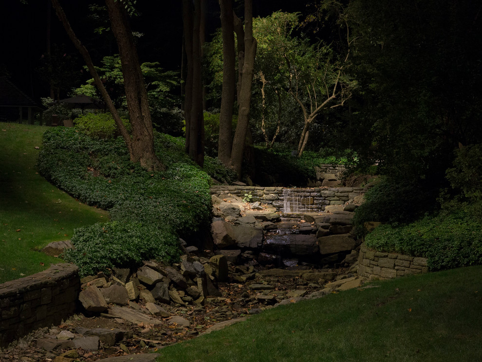 Large traditional backyard garden in New York with a retaining wall.