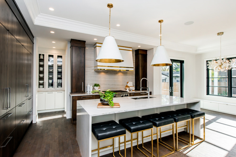 Kitchen pantry - large transitional l-shaped medium tone wood floor and brown floor kitchen pantry idea in Calgary with a double-bowl sink, flat-panel cabinets, marble countertops, white backsplash, stone slab backsplash, paneled appliances, an island and dark wood cabinets