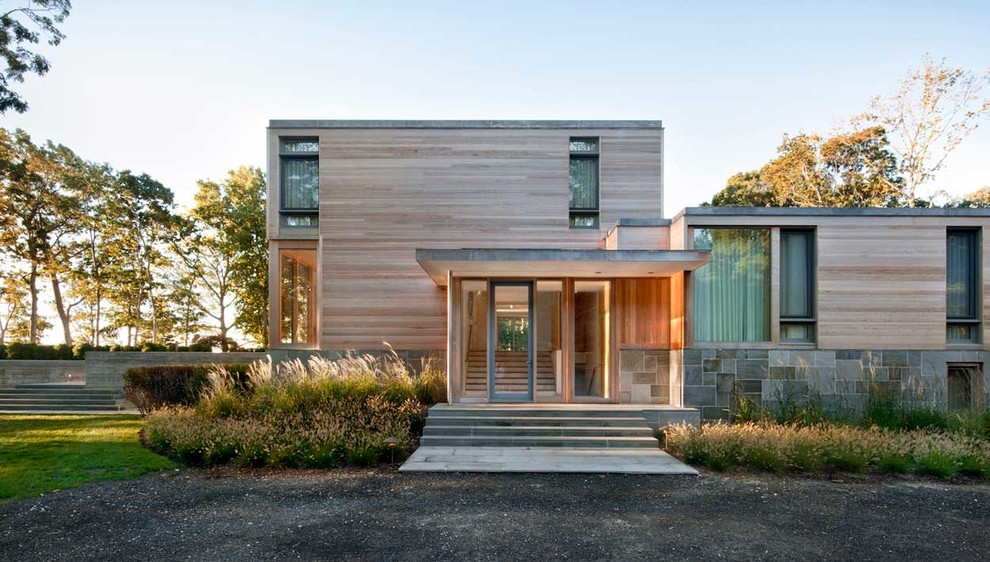 Inspiration for a modern two-storey brown exterior in New York with wood siding and a flat roof.