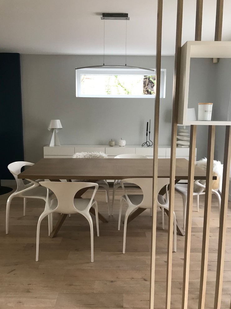 Large scandinavian dining room in Paris with grey walls, light hardwood floors and beige floor.
