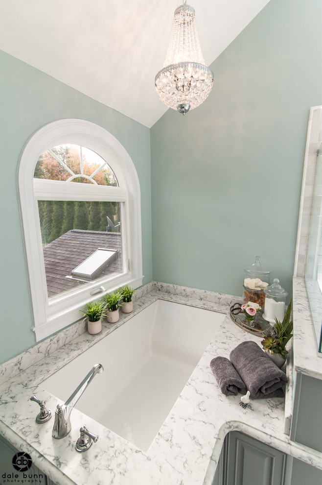 Design ideas for a mid-sized traditional master bathroom in Boston with raised-panel cabinets, blue cabinets, an undermount tub, a double shower, a two-piece toilet, black and white tile, stone tile, blue walls, marble floors, an undermount sink and engineered quartz benchtops.