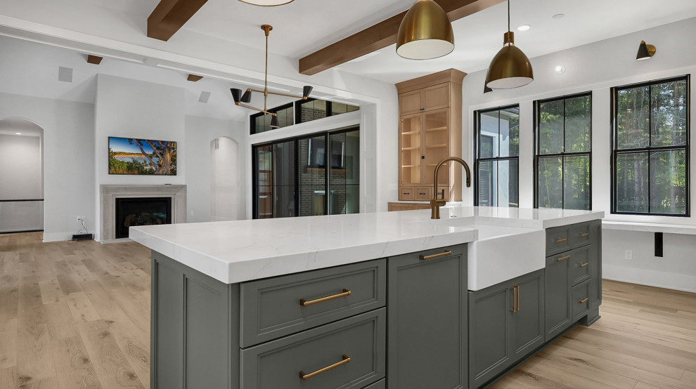 Transitional u-shaped exposed beam open concept kitchen photo in Columbus with a farmhouse sink, shaker cabinets, green cabinets, quartz countertops, subway tile backsplash, stainless steel appliances, an island and white countertops