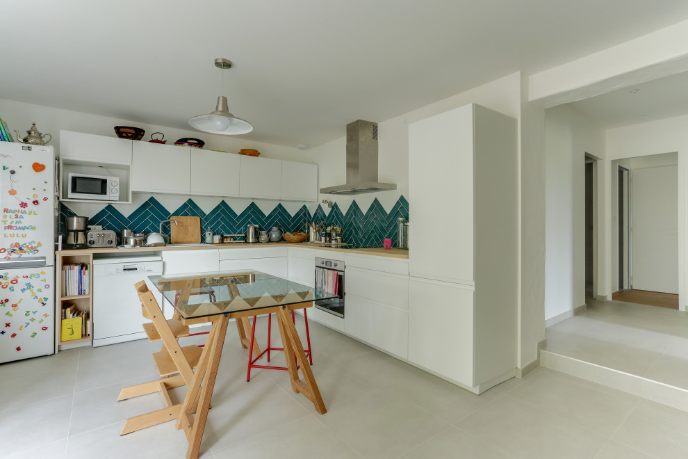 This is an example of a small scandinavian l-shaped eat-in kitchen in Other with ceramic floors, flat-panel cabinets, white cabinets, wood benchtops, blue splashback, ceramic splashback, stainless steel appliances, beige benchtop, no island and grey floor.