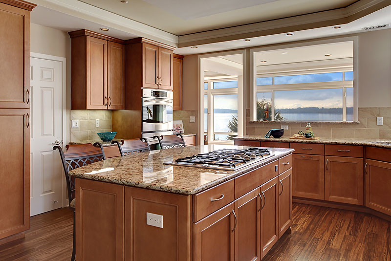 Design ideas for a large transitional u-shaped open plan kitchen in Seattle with an undermount sink, beaded inset cabinets, medium wood cabinets, granite benchtops, beige splashback, porcelain splashback, stainless steel appliances, bamboo floors and with island.