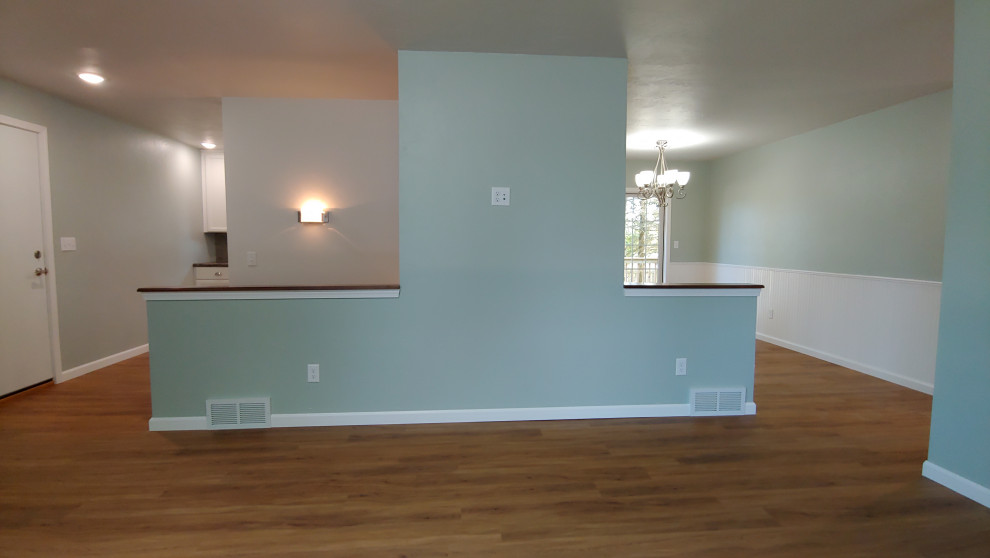Foto di un piccolo soggiorno chic aperto con pareti grigie, pavimento in vinile, TV a parete e pavimento marrone