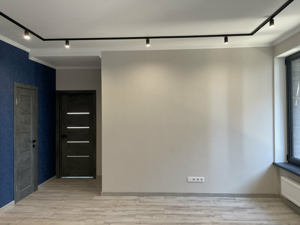 Cette photo montre un salon tendance de taille moyenne et ouvert avec un mur bleu, sol en stratifié, un sol beige et du papier peint.