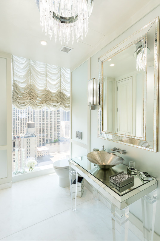 Mid-sized transitional powder room in New York with glass-front cabinets, a one-piece toilet, white tile, glass tile, marble floors, a vessel sink, glass benchtops and white floor.