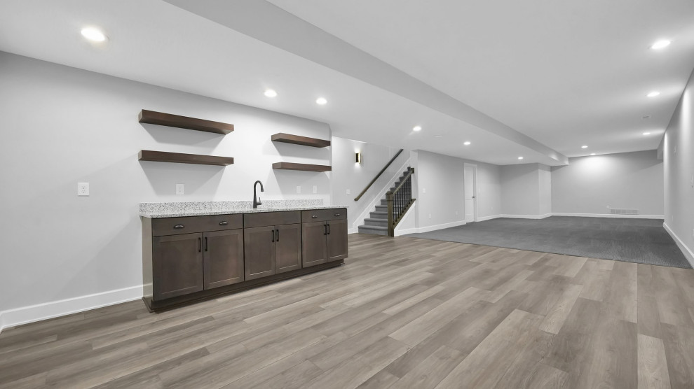 Inspiration for a transitional underground basement remodel in Columbus with a bar