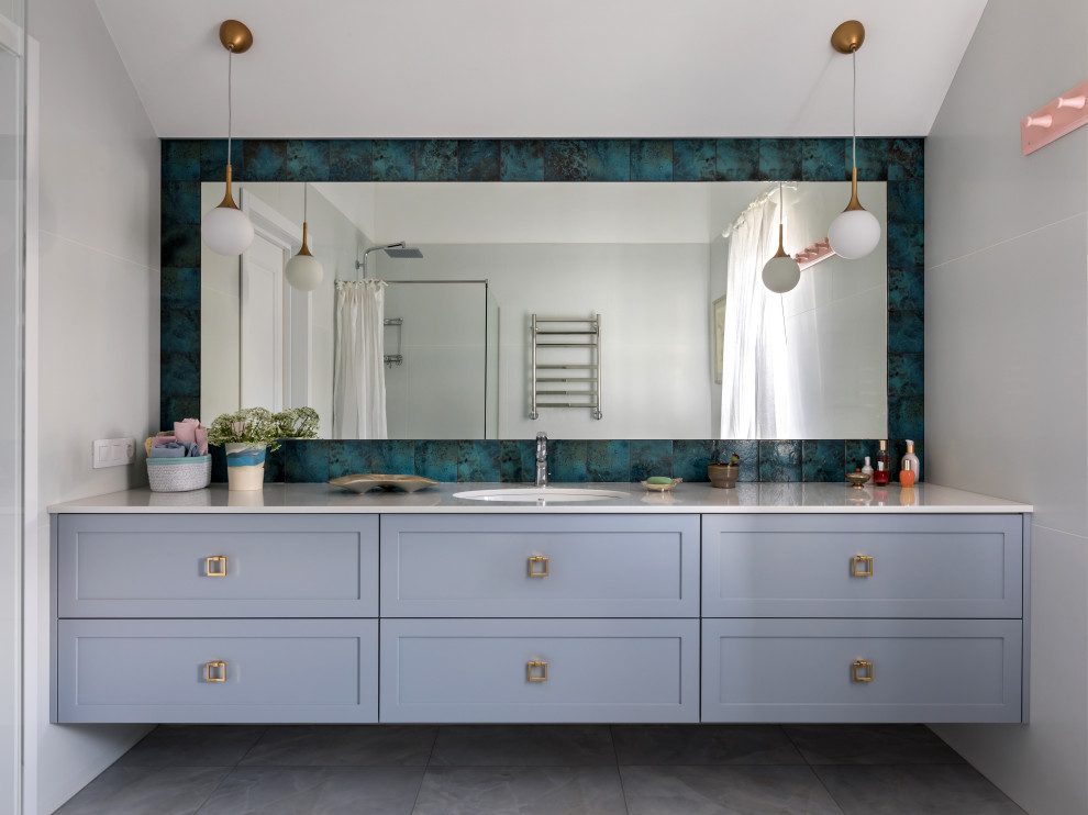 This is an example of a medium sized eclectic ensuite bathroom in Other with grey cabinets, a walk-in shower, white tiles, white walls, porcelain flooring, a submerged sink, solid surface worktops, grey floors, a shower curtain, white worktops, a single sink and a floating vanity unit.