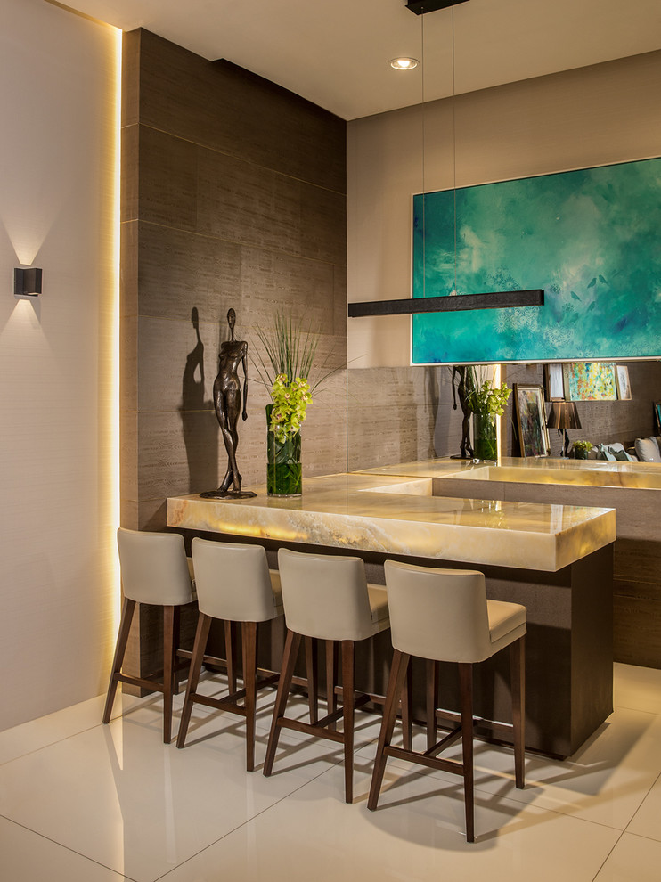 This is an example of a contemporary l-shaped seated home bar in Miami with mirror splashback.
