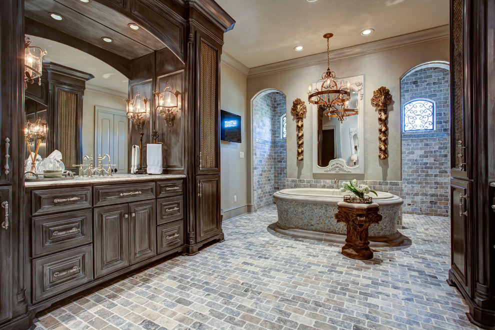 Expansive traditional master bathroom in Little Rock with recessed-panel cabinets, distressed cabinets, a drop-in tub, an open shower, multi-coloured tile, stone tile, grey walls, slate floors and an undermount sink.