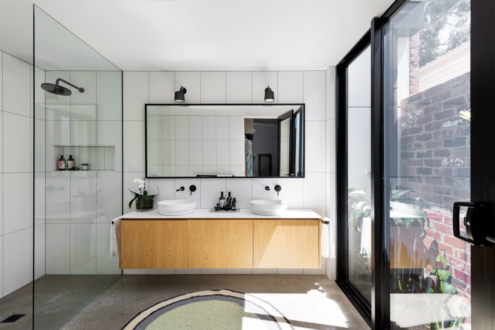 Photo of a large contemporary master bathroom in Melbourne with flat-panel cabinets, stone tile, white walls, concrete floors, engineered quartz benchtops, grey floor, an open shower, white benchtops, light wood cabinets, a curbless shower, white tile and a vessel sink.