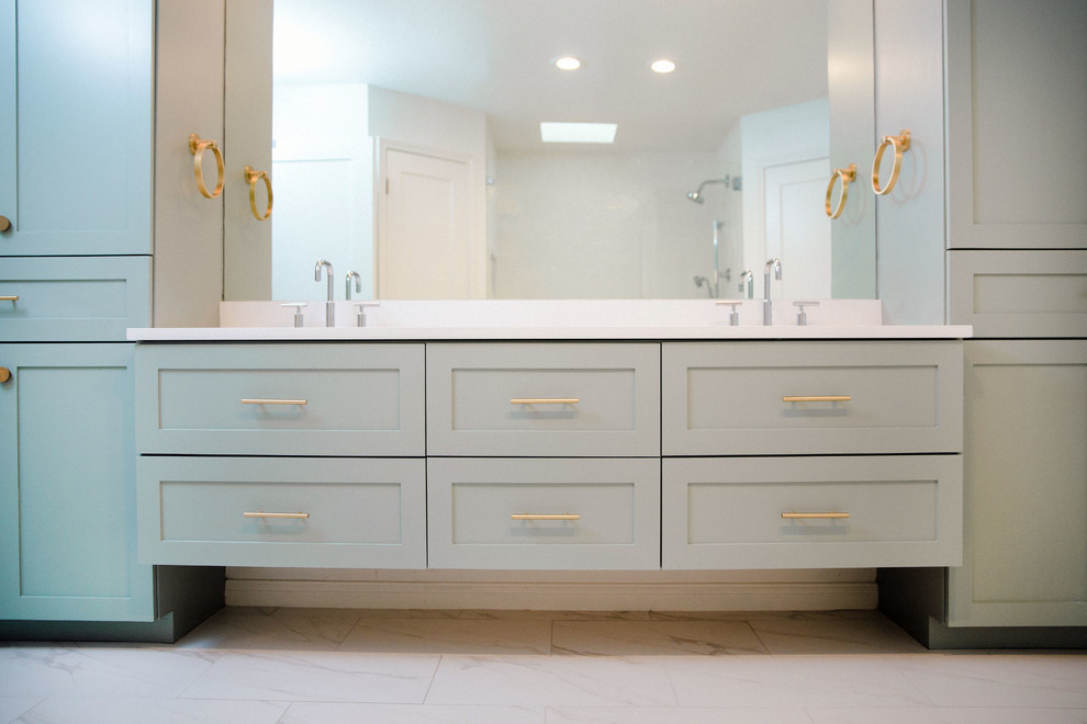 Photo of a large transitional master bathroom in Austin with shaker cabinets, blue cabinets, white tile, white walls, ceramic floors, a drop-in sink, engineered quartz benchtops, white floor, a hinged shower door and white benchtops.