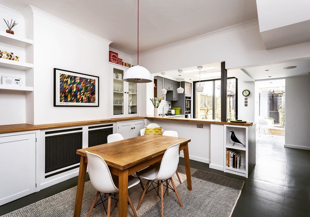 Small contemporary kitchen/dining combo in London with white walls and grey floor.