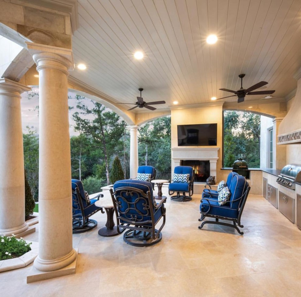 This is an example of a large mediterranean backyard patio in Dallas with an outdoor kitchen, tile and a roof extension.