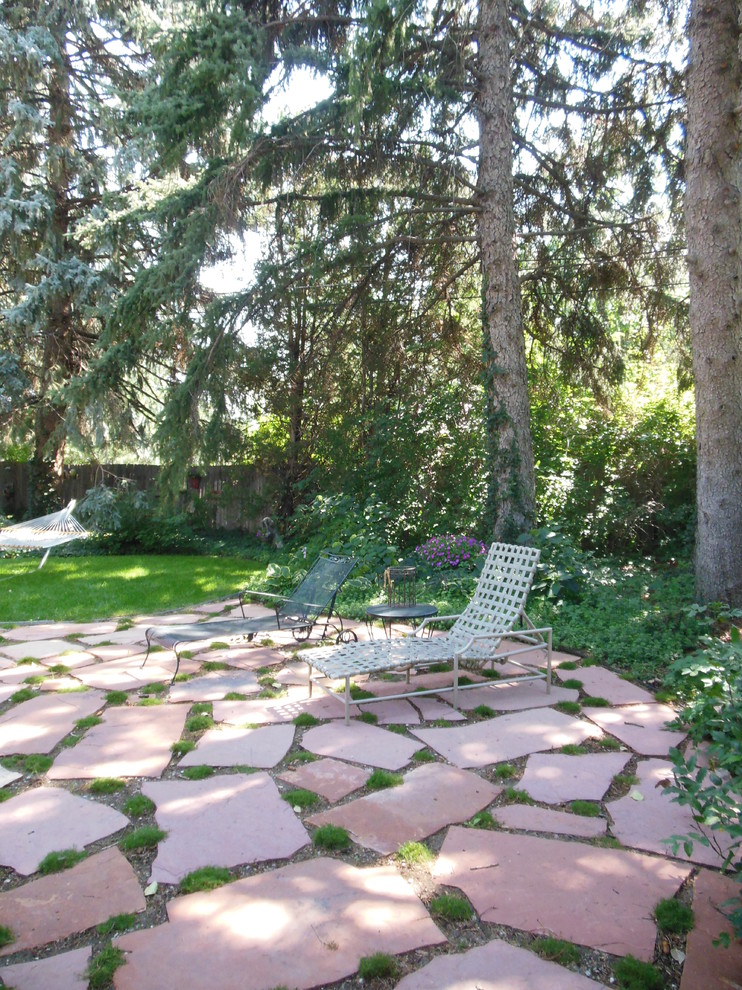 Photo of a traditional patio in Denver with natural stone pavers and no cover.