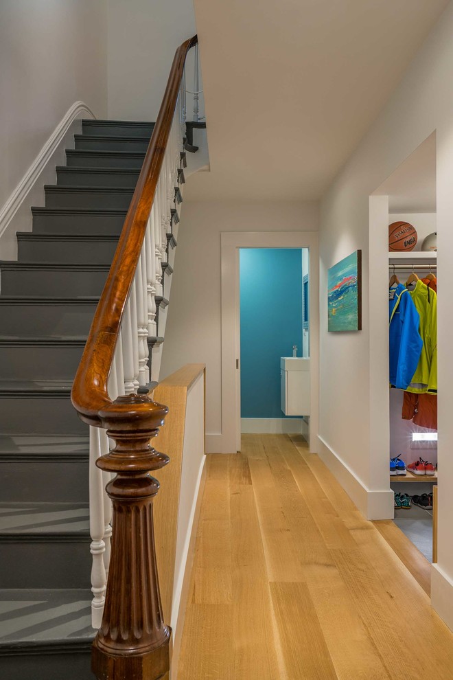 Hallway - mid-sized transitional medium tone wood floor hallway idea in Boston with white walls