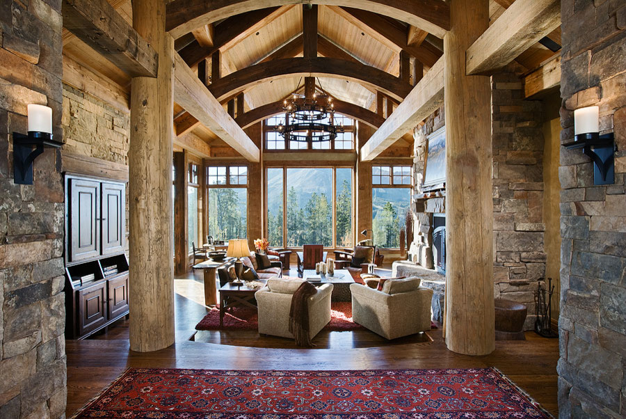 This is an example of a large country open concept living room in Other with brown walls, dark hardwood floors, a standard fireplace, a stone fireplace surround and brown floor.