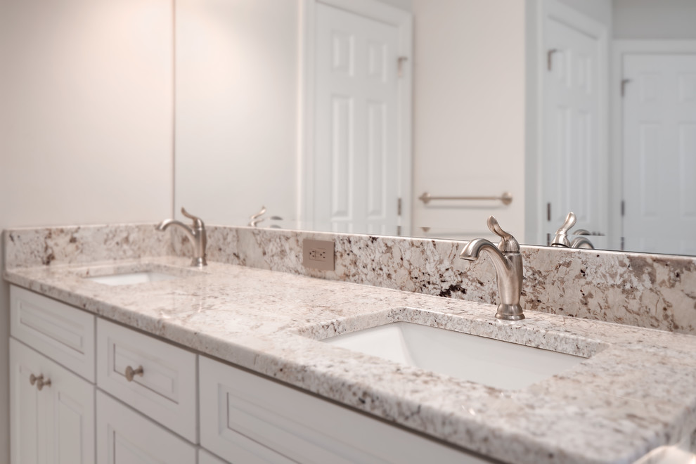 Inspiration for a large transitional master gray tile and porcelain tile porcelain tile and gray floor freestanding bathtub remodel with raised-panel cabinets, white cabinets, a two-piece toilet, gray walls, an undermount sink, granite countertops and a hinged shower door