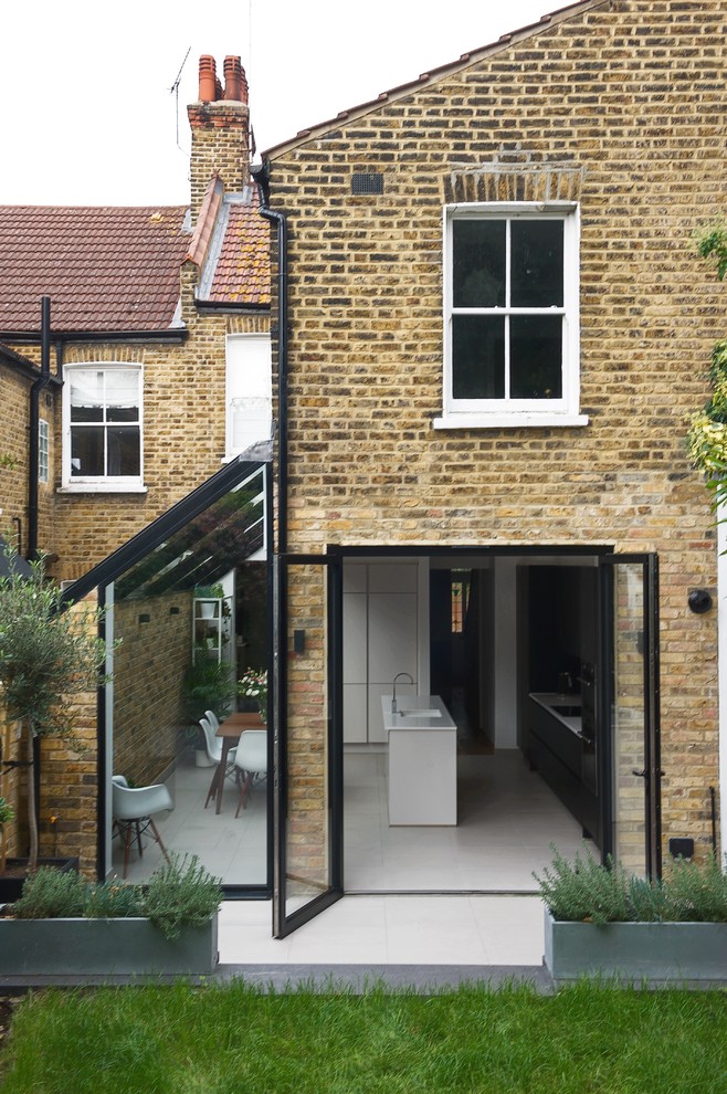 Photo of a mid-sized contemporary three-storey brick townhouse exterior in London.