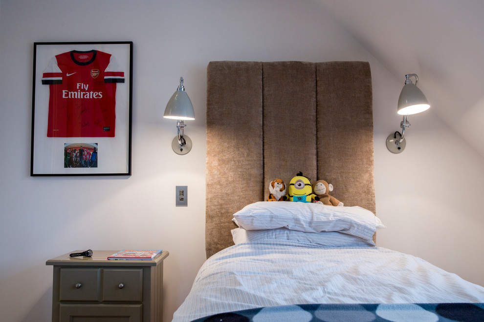 Mid-sized contemporary kids' bedroom in London with beige walls and light hardwood floors for kids 4-10 years old and boys.