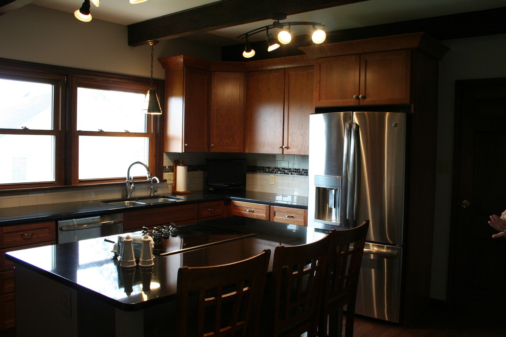 Inspiration for a mid-sized transitional l-shaped medium tone wood floor kitchen remodel with an undermount sink, medium tone wood cabinets, granite countertops, white backsplash, subway tile backsplash, stainless steel appliances, an island and recessed-panel cabinets