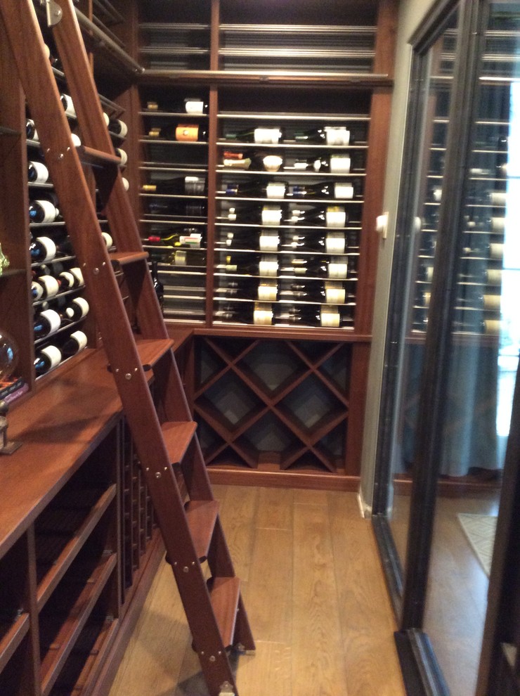 Design ideas for a mid-sized contemporary wine cellar in Orange County with storage racks and light hardwood floors.