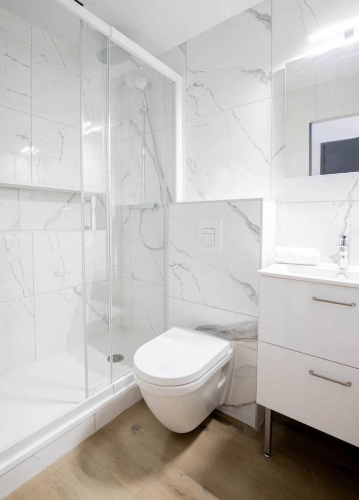 Mid-sized contemporary master bathroom in Lyon with white cabinets, a wall-mount toilet, white tile, marble, white walls, wood-look tile, a pedestal sink, beige floor, white benchtops, a single vanity, a freestanding vanity, beaded inset cabinets and a sliding shower screen.