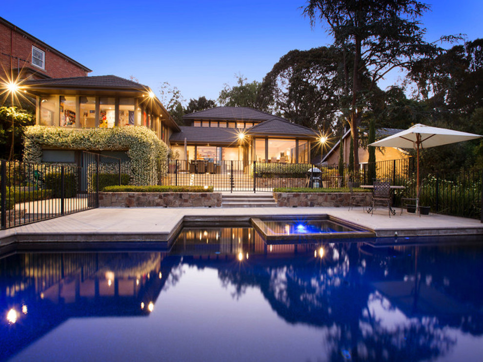 Photo of a large contemporary three-storey concrete brown exterior in Melbourne with a hip roof.