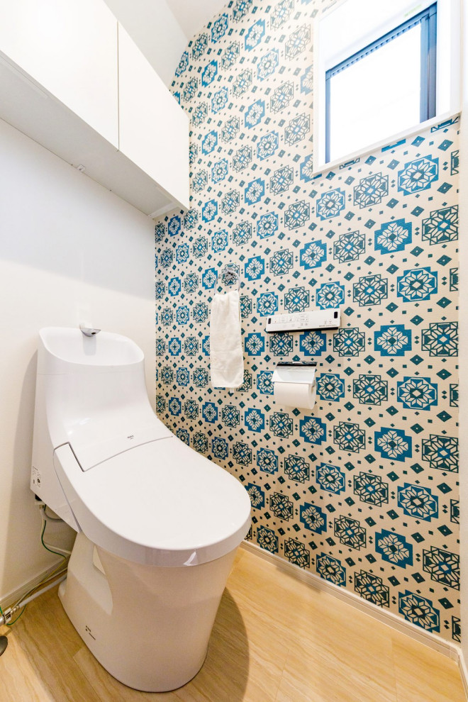 他の地域にある高級な中くらいなインダストリアルスタイルのおしゃれなトイレ・洗面所 (一体型トイレ	、マルチカラーの壁、淡色無垢フローリング、ベージュの床、クロスの天井、壁紙) の写真