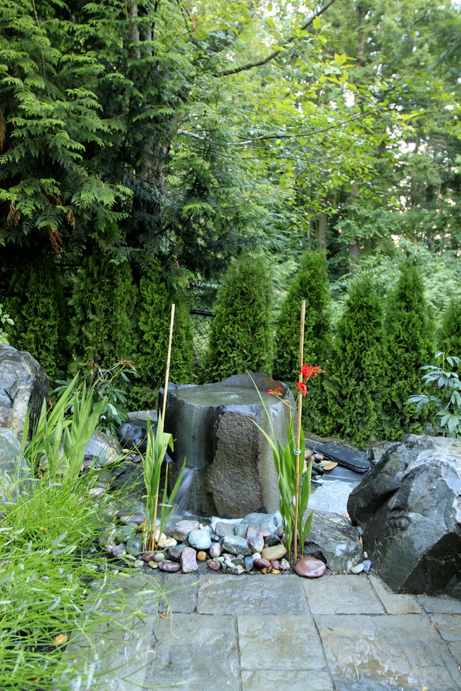Photo of a traditional backyard garden in Seattle with a water feature.