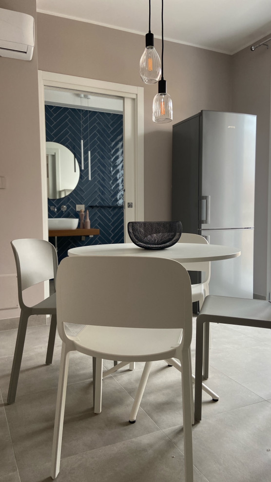 Esempio di una sala da pranzo aperta verso il soggiorno minimalista con pareti beige, pavimento in gres porcellanato e pavimento beige