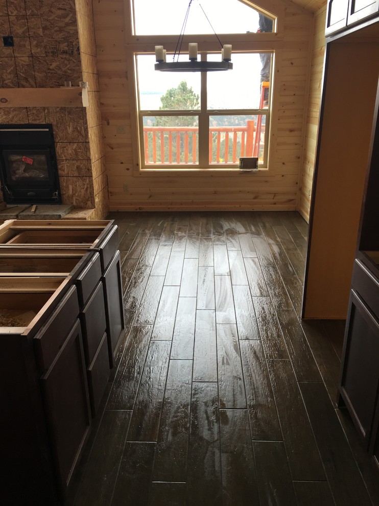 Large mountain style l-shaped porcelain tile home design photo with flat-panel cabinets, dark wood cabinets and an island