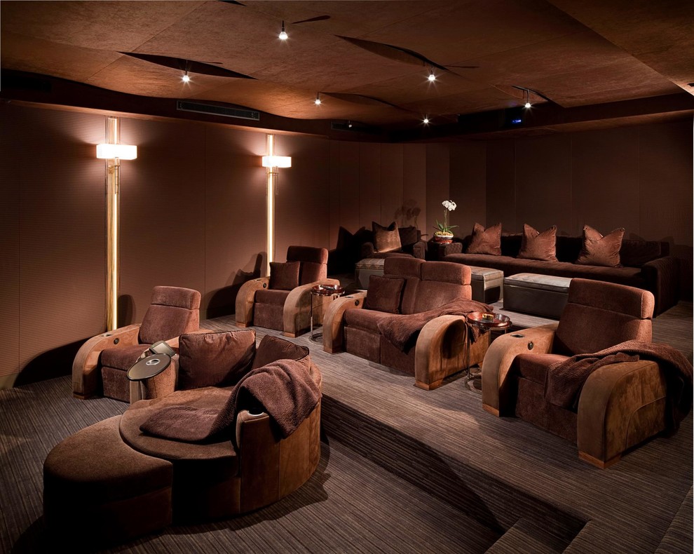 This is an example of a large contemporary enclosed home theatre in Las Vegas with brown walls, carpet and brown floor.