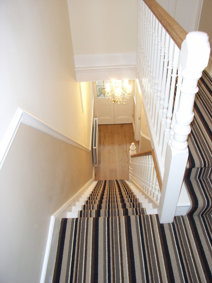 This is an example of a mid-sized contemporary carpeted u-shaped staircase in Other with carpet risers.
