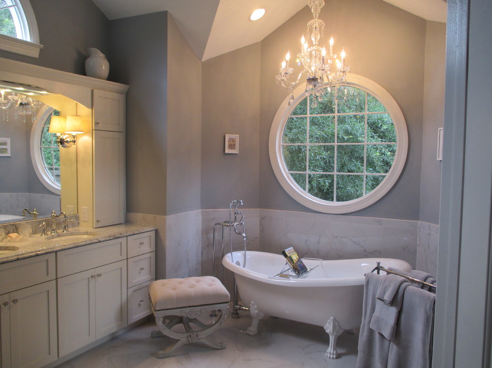 Photo of a traditional master bathroom in Charlotte with white cabinets, marble benchtops, a claw-foot tub, a corner shower, porcelain tile, grey walls and porcelain floors.
