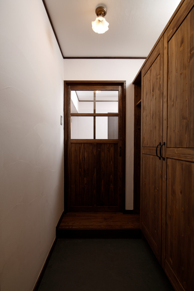 Ispirazione per un piccolo corridoio con pareti bianche, pavimento in linoleum, una porta singola, una porta in legno scuro, pavimento grigio, soffitto in carta da parati e armadio