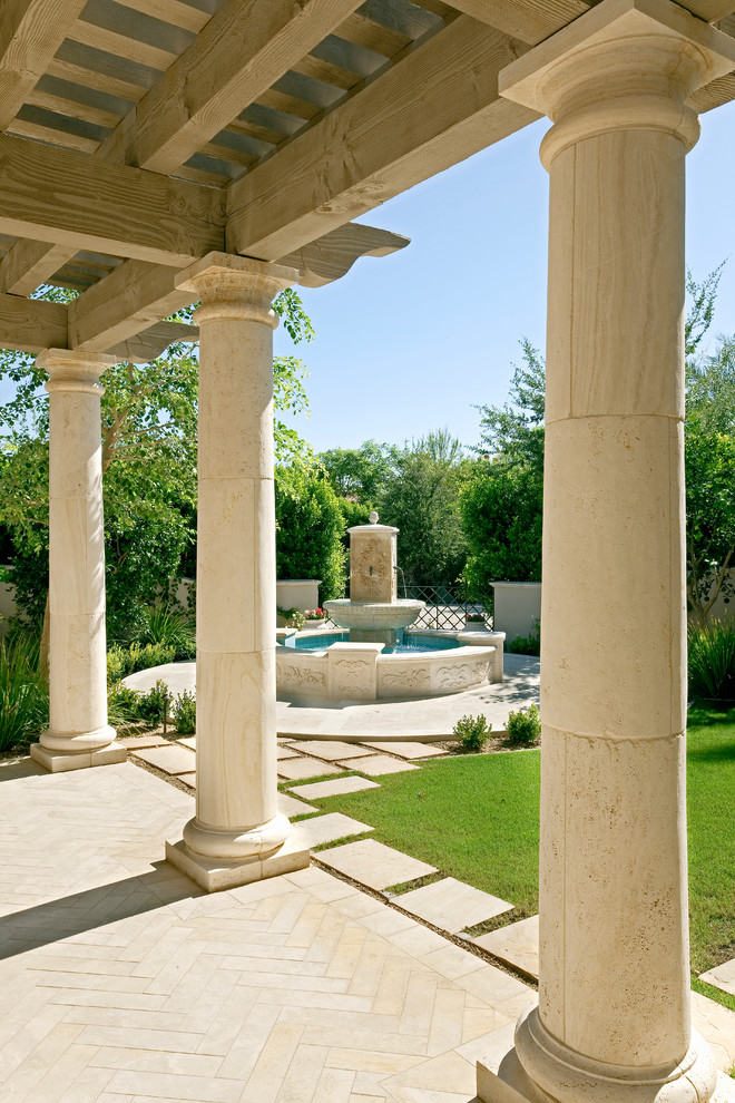This is an example of a mediterranean verandah in Phoenix with a water feature and tile.