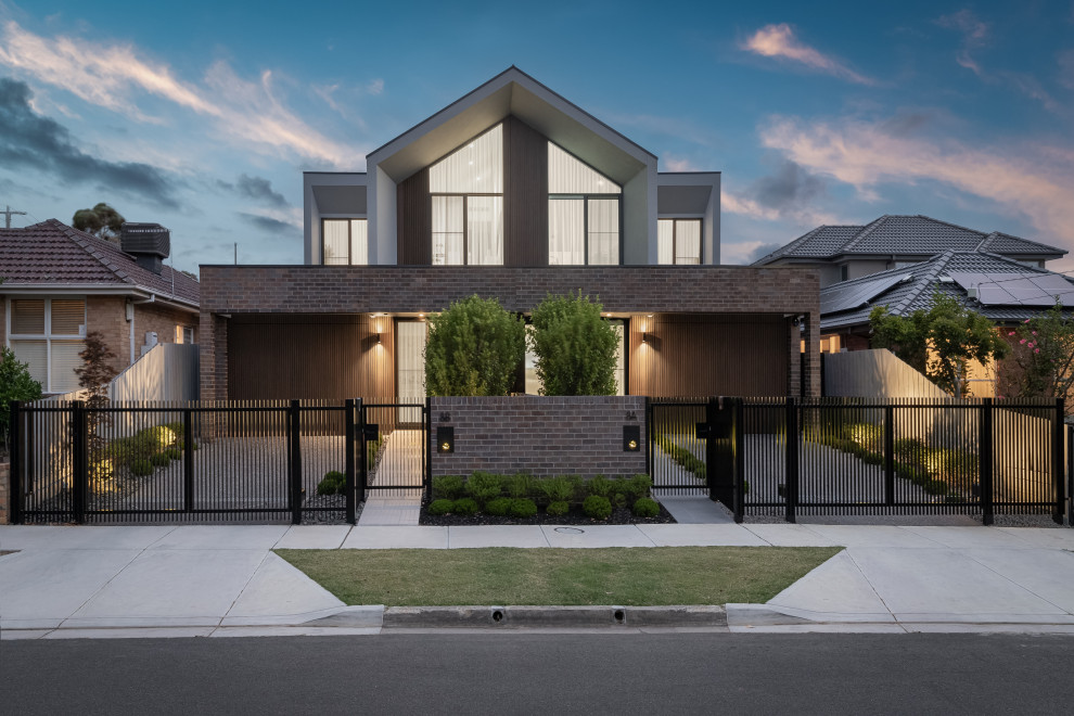Design ideas for a contemporary two-storey house exterior in Melbourne with mixed siding and a gable roof.