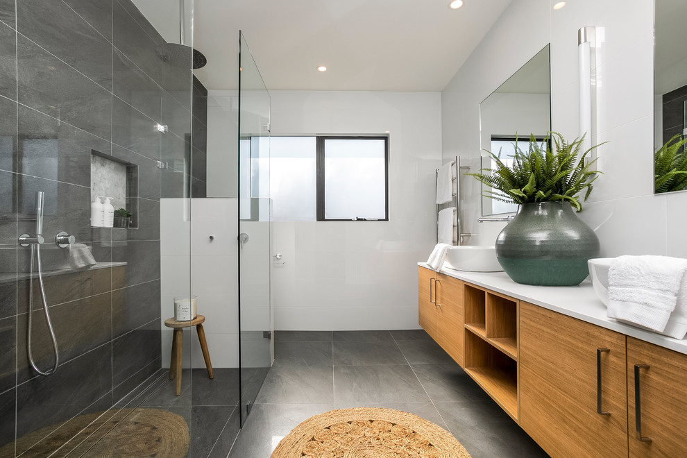 Contemporary master bathroom in Sydney with flat-panel cabinets, brown cabinets, a curbless shower, gray tile, white walls, a vessel sink, grey floor, an open shower and white benchtops.