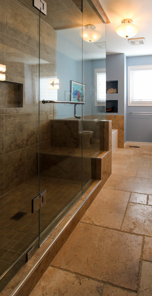 This is an example of a large beach style master bathroom in Toronto with recessed-panel cabinets, dark wood cabinets, a drop-in tub, a double shower, a two-piece toilet, beige tile, porcelain tile, blue walls, travertine floors, an undermount sink and engineered quartz benchtops.