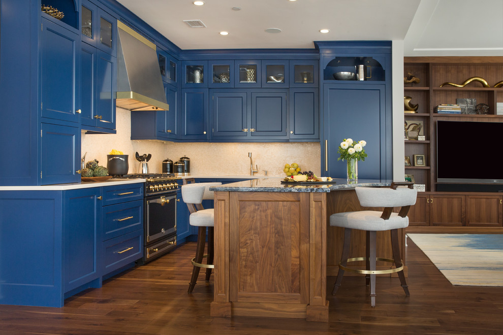 Inspiration for a mid-sized traditional l-shaped eat-in kitchen in New York with an undermount sink, recessed-panel cabinets, blue cabinets, granite benchtops, beige splashback, stone tile splashback, black appliances, medium hardwood floors and with island.