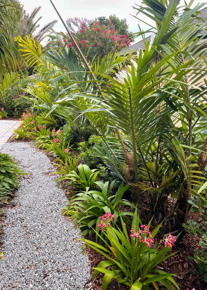 Inspiration for a mid-sized tropical side yard partial sun garden in Jacksonville with with privacy feature and gravel.