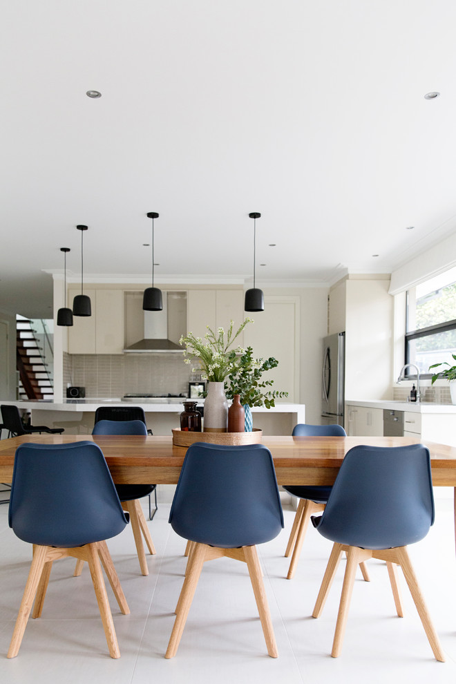 Mid-sized contemporary kitchen/dining combo in Melbourne with white walls, porcelain floors, no fireplace and beige floor.