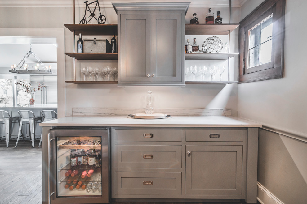 Inspiration for a small transitional single-wall wet bar in Columbus with no sink, shaker cabinets, grey cabinets, marble benchtops, white splashback, marble splashback, dark hardwood floors and brown floor.