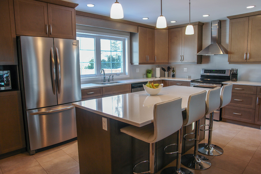 Example of a mid-sized transitional l-shaped ceramic tile and beige floor eat-in kitchen design with an undermount sink, shaker cabinets, medium tone wood cabinets, quartzite countertops, beige backsplash, porcelain backsplash, stainless steel appliances and an island