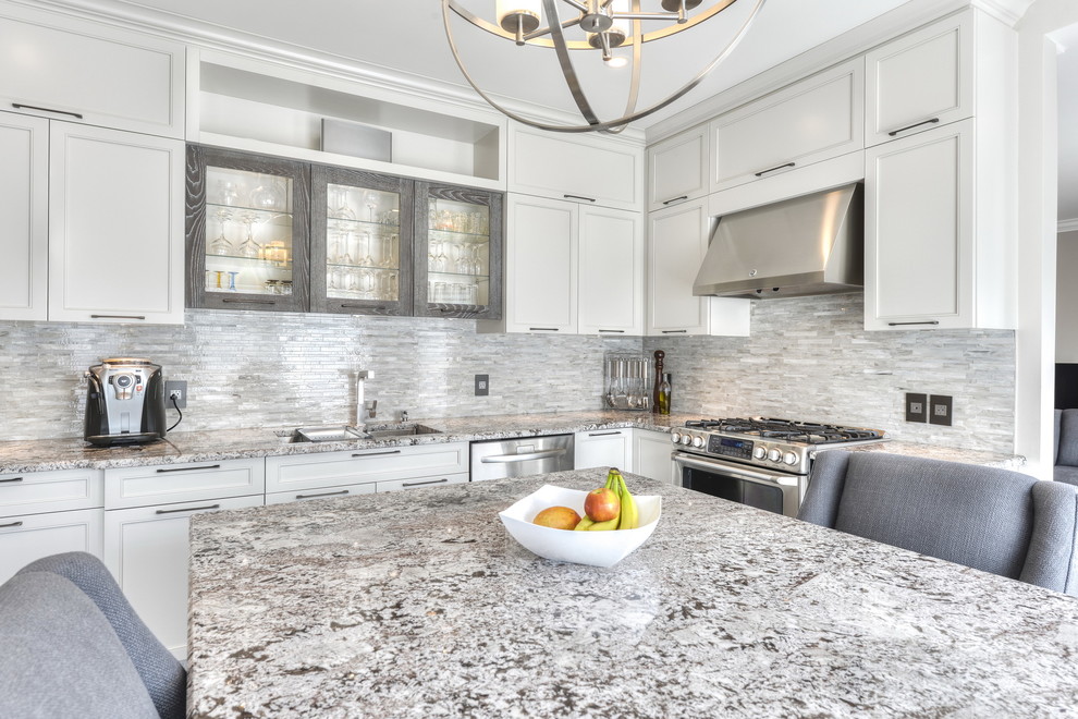 Design ideas for a large transitional u-shaped separate kitchen in Montreal with an undermount sink, shaker cabinets, beige cabinets, granite benchtops, beige splashback, glass tile splashback, stainless steel appliances, porcelain floors and with island.