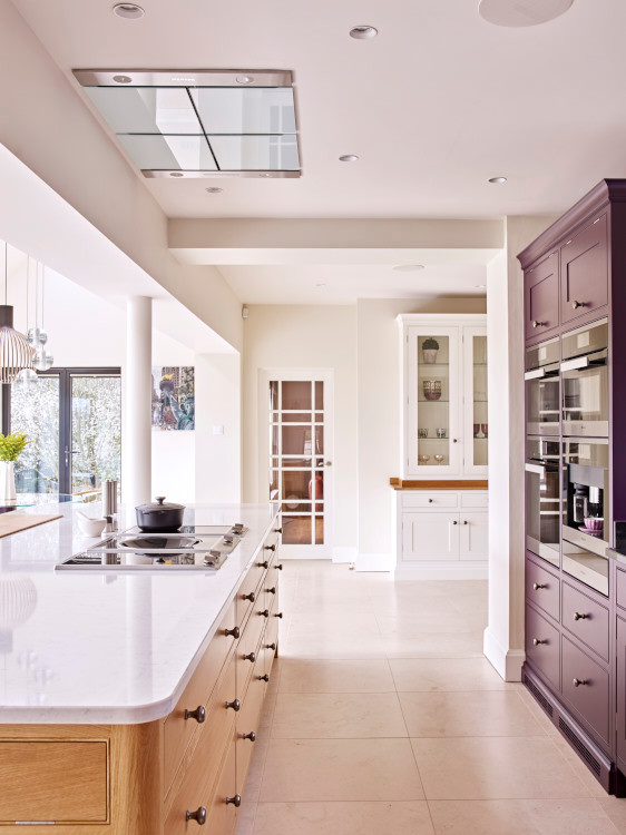 Large contemporary eat-in kitchen in Other with an integrated sink, shaker cabinets, purple cabinets, granite benchtops, stainless steel appliances, limestone floors, with island, beige floor and white benchtop.