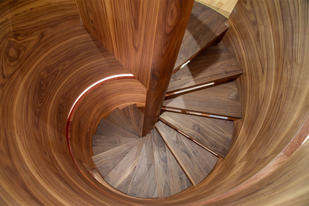 На фото: винтовая деревянная лестница в стиле ретро с стеклянными ступенями и деревянными перилами с
