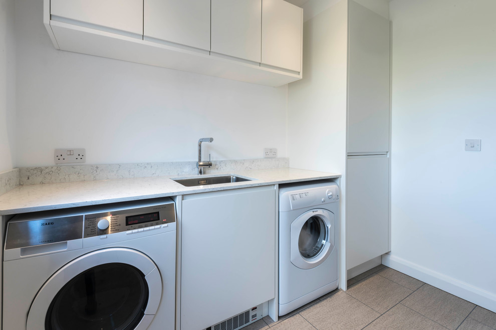 Design ideas for a mid-sized contemporary single-wall laundry room in Sussex.
